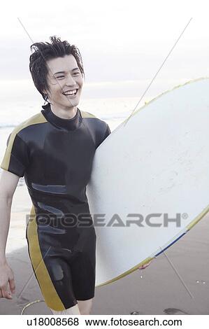Stock Photo - Male Surfer at Enoshima beach. Fotosearch