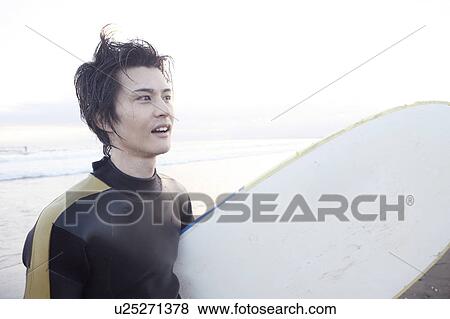 Stock Photo - Male surfer at Enoshima beach. Fotosearch