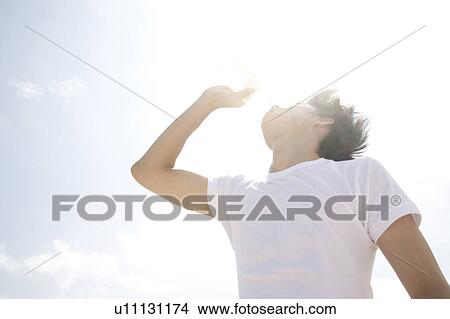 Picture - Man drinking a bottle of water. Fotosearch