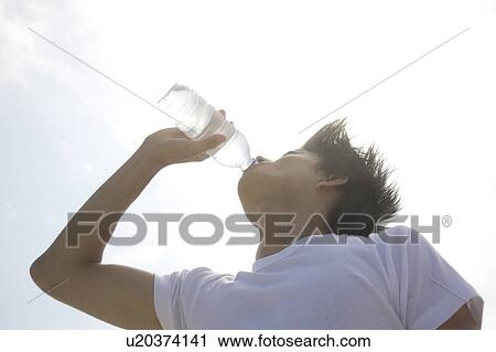Stock Image - Man drinking a bottle of water. Fotosearch