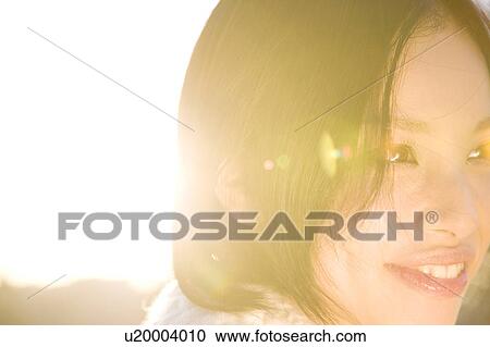 Stock Image - Portrait of a young woman outdoors. Fotosearch