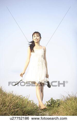 Stock Photograph - Portrait of woman walking barefoot. Fotosearch