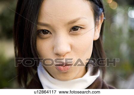 Stock Photo - Portrait of young woman making a face. Fotosearch