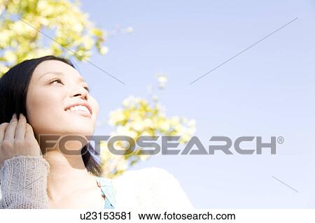 Stock Image - Portrait of young woman outside. Fotosearch