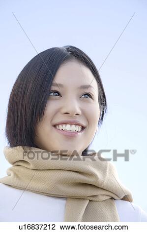 Stock Image - Portrait of young woman wearing a scarf. Fotosearch