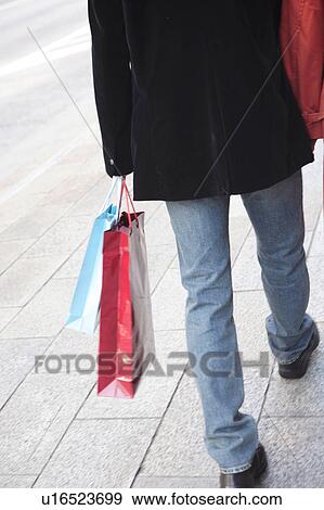Rear view of man carrying gift bags View Large Photo Image Stock Photo - Rear view of man carrying gift bags. Fotosearch