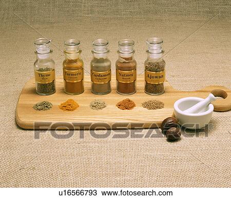 Stock Image - Row of spices on a cutting board. Fotosearch