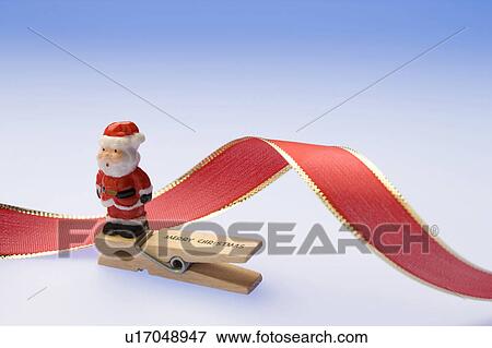 Stock Photo - Santa Claus on a clothespin and ribbon. Fotosearch