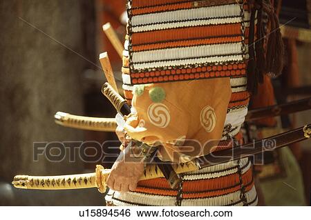 Stock Photograph - Side view of a man holding a samurai sword. Fotosearch