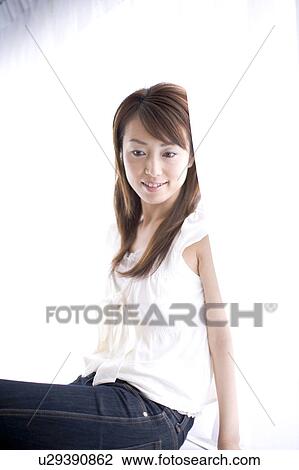 Stock Image - Side view of a seated young woman. Fotosearch