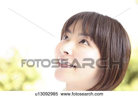 Stock Photography - Smiling woman looking up. Fotosearch