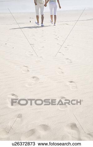 Stock Image - Tracks of couple on a beach. Fotosearch