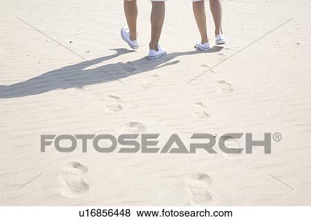 Stock Photo - Tracks of couple on a beach. Fotosearch