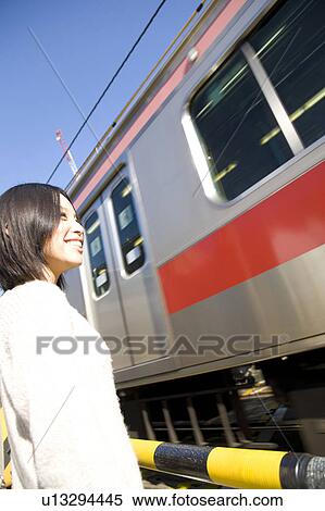Stock Photography - Woman at train crossing. Fotosearch