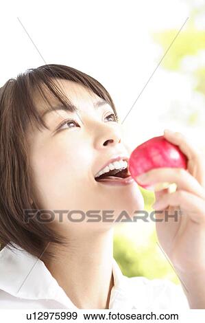 Stock Photo - Woman eating apple. Fotosearch