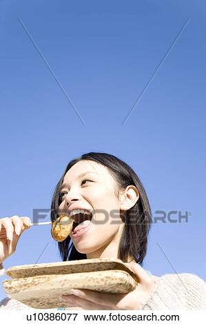 Woman eating Takoyaki View Large Photo Image Stock Photo - Woman eating Takoyaki. Fotosearch