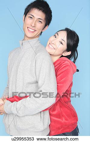 Stock Image - Woman embracing a man from back. Fotosearch