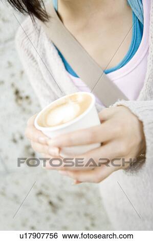 Stock Photograph - Woman holding cafe latte. Fotosearch