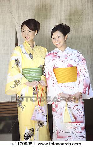 Stock Image - Women putting on a yukata. Fotosearch