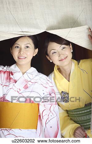 Stock Image - Women putting on a yukata. Fotosearch