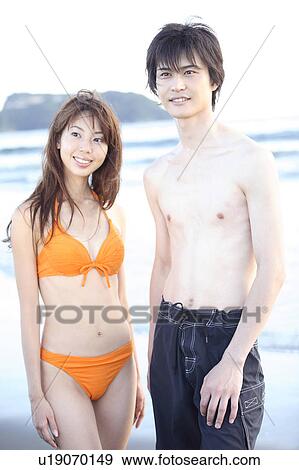 Stock Photo - Young couple on the beach in Enoshima. Fotosearch