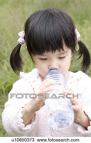 Stock Image - Young girl drinking a water. Fotosearch