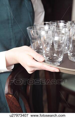 Young waitress carrying glasses View Large Photo Image Stock Photo - Young waitress carrying glasses. Fotosearch