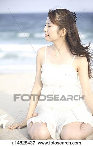 Young woman feeling wind on a beach View Large Photo Image Stock Photo - Young woman feeling wind on a beach. Fotosearch