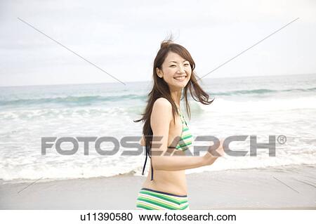 Young woman walking on a beach in swimsuit View Large Photo Image Stock Image - Young woman walking on a beach in swimsuit. Fotosearch