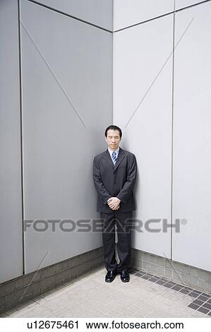 Businessman standing in a corner with his hands clasped View Large Photo Image Stock Image - Businessman standing in a corner with his hands clasped. Fotosearch