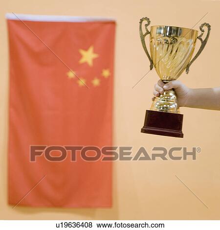 Close-up of a person's hand holding a golden trophy cup View Large Photo Image Stock Photo - Close-up of a person's hand holding a golden trophy cup. Fotosearch