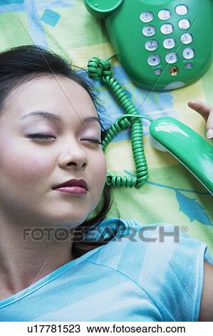 Close-up of a young woman sleeping with a telephone beside her View Large Photo Image Stock Image - Close-up of a young woman sleeping with a telephone beside her. Fotosearch
