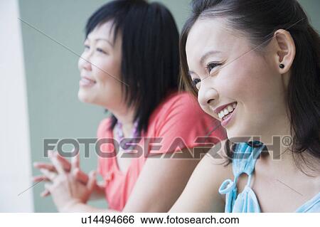 Close-up of a young woman standing in a balcony with her mother and smiling View Large Photo Image Stock Photograph - Close-up of a young woman standing in a balcony with her mother and smiling. Fotosearch