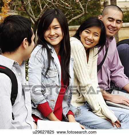 Four college students sitting in a college campus and smiling View Large Photo Image Stock Photography - Four college students sitting in a college campus and smiling. Fotosearch