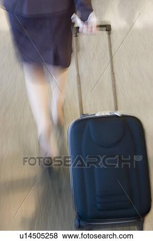 Low section view of a businesswoman pulling her luggage View Large Photo Image Stock Photo - Low section view of a businesswoman pulling her luggage. Fotosearch