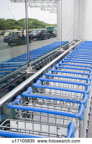 Luggage carts in a row at an airport View Large Photo Image Stock Photography - Luggage carts in a row at an airport. Fotosearch