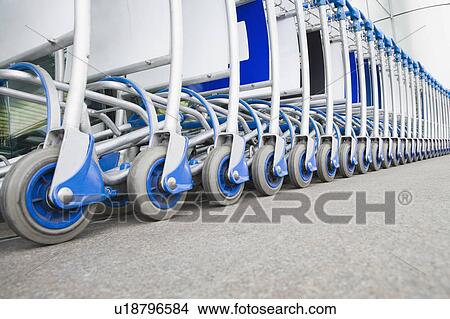 Luggage carts in a row outside an airport View Large Photo Image Picture - Luggage carts in a row outside an airport. Fotosearch