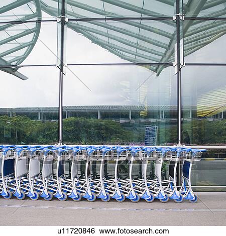 Stock Photograph - Luggage carts in a row outside an airport. Fotosearch
