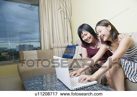 Mature woman and her daughter using a laptop and smiling View Large Photo Image Stock Photo - Mature woman and her daughter using a laptop and smiling. Fotosearch