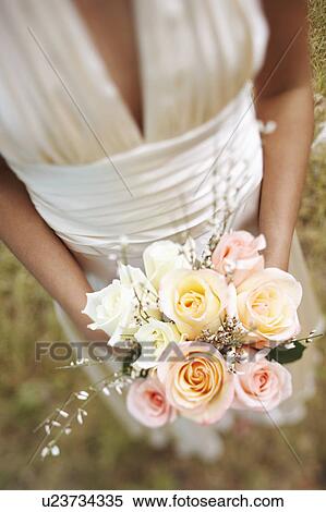 Mid section view of a bride holding a bouquet of flowers View Large Photo Image Stock Photography - Mid section view of a bride holding a bouquet of flowers. Fotosearch