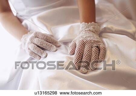 Stock Photo - Mid section view of a bride wearing a wedding ring. Fotosearch