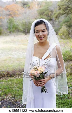 Portrait of a bride holding a bouquet of flowers and smiling View Large Photo Image Stock Image - Portrait of a bride holding a bouquet of flowers and smiling. Fotosearch