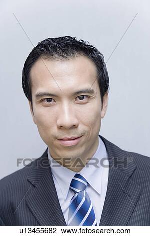 Stock Image - Portrait of a businessman smirking. Fotosearch