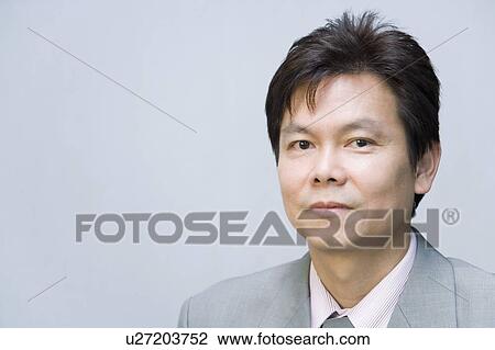 Stock Image - Portrait of a businessman smirking. Fotosearch