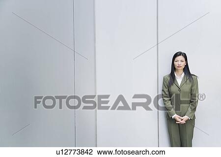 Stock Image - Portrait of a businesswoman standing with her hands clasped. Fotosearch
