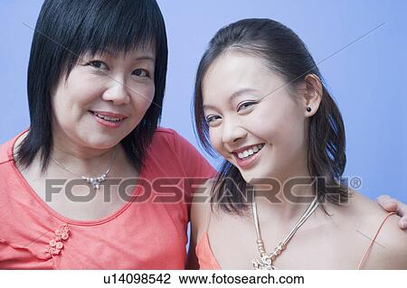 Stock Image - Portrait of a mature woman and her daughter smiling. Fotosearch