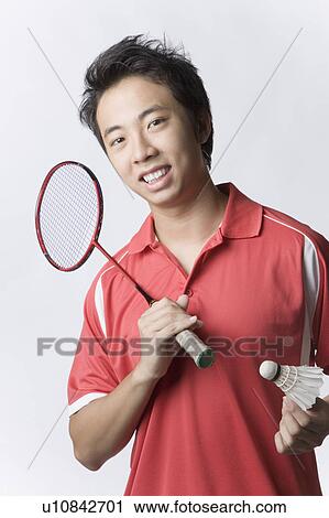 Portrait of a young man holding a badminton racket and a shuttlecock View Large Photo Image Stock Image - Portrait of a young man holding a badminton racket and a shuttlecock. Fotosearch