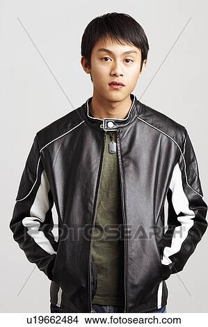 Picture - Portrait of a young man standing with his hands in his pockets. Fotosearch