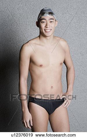 Stock Photo - Portrait of a young man wearing a swimming cap and smiling. Fotosearch