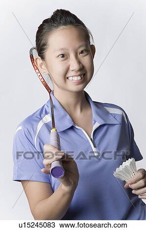 Stock Image - Portrait of a young woman holding a badminton racket and a shuttlecock. Fotosearch